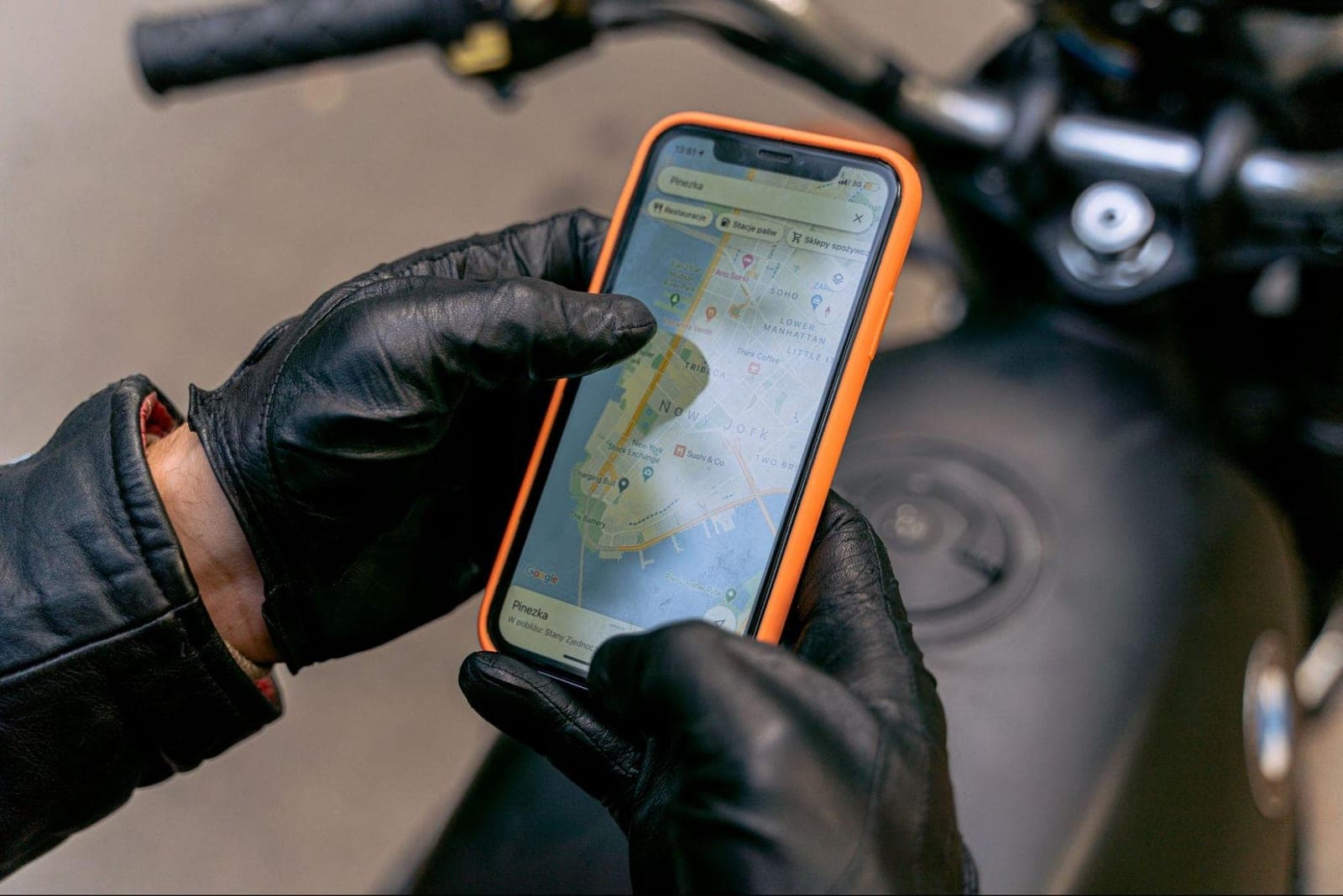 A rider checking a motorcycle navigation app on their phone before a ride